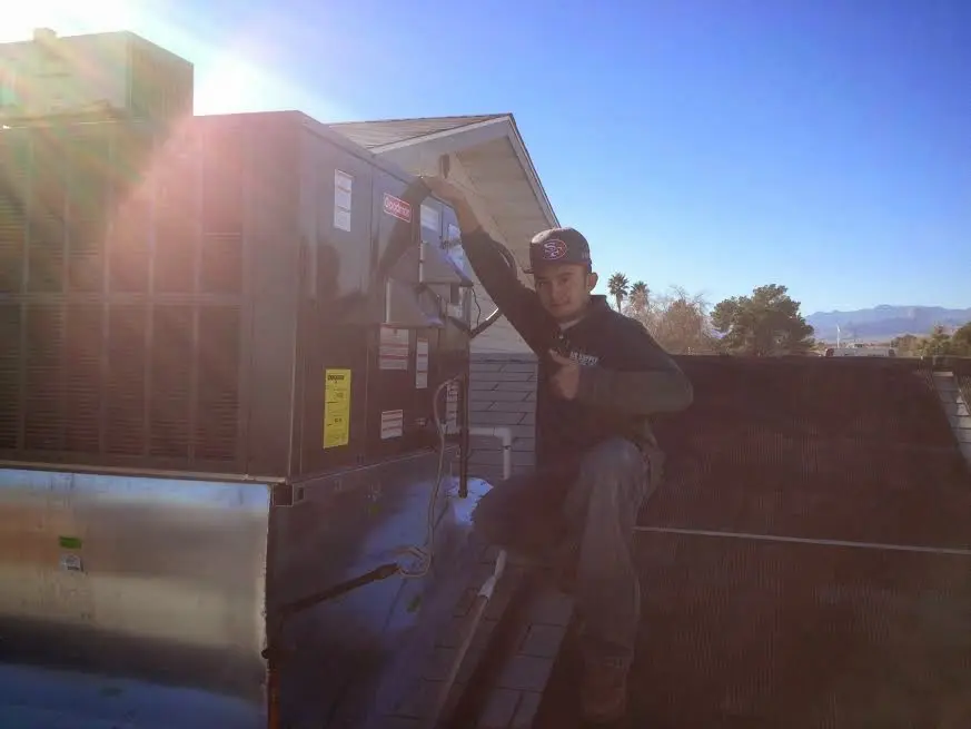 HVAC technician performing AC Tune-Up on a rooftop unit in Hellertown